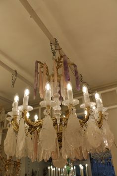 a chandelier hanging from the ceiling in a room with many lights on it