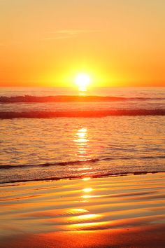 the sun is setting over the water at the beach