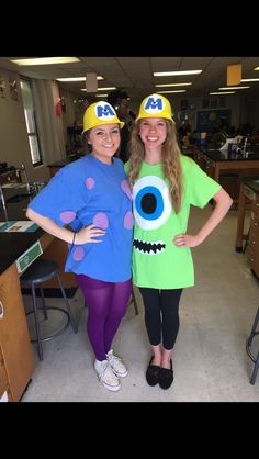 two girls in costumes standing next to each other wearing hats and eyeballs on their faces