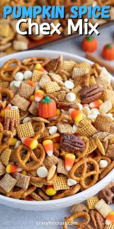 a bowl full of halloween snack mix with candy corn, pretzels and candies