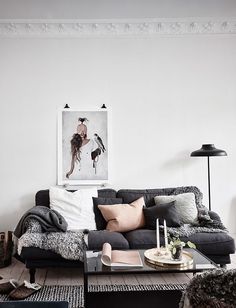 a living room filled with furniture and a painting on the wall above it's coffee table