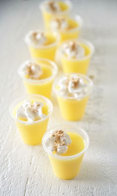 small cups filled with food sitting on top of a white table covered in frosting