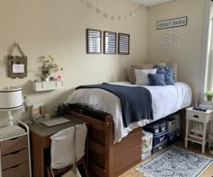 a bed room with a neatly made bed next to a desk and chair near a window