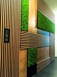 a green wall with wooden panels and grass growing on it