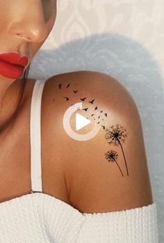 a woman's shoulder with a dandelion tattoo on her left arm and red lipstick