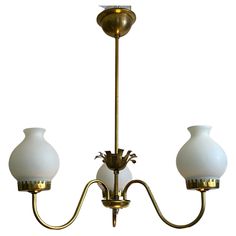 three light brass chandelier with white glass shades