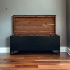 an empty wooden chest sitting on top of a hard wood floor