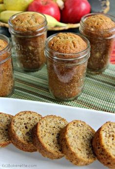 banana bread in jars on a table with apples and bananas