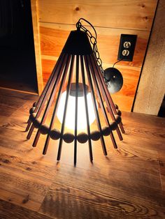 a lamp that is on top of a wooden table next to a light bulb and some wires