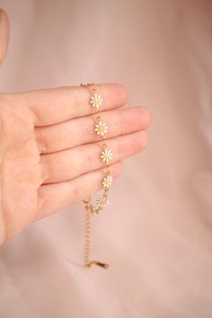 Beautifully blooming, this Daisy Chain Bracelet is the perfect way to accessorize your summer wardrobe. Crafted with dainty daisies and adjustable to fit any wrist size, this bracelet is the sweetest of statements. Stunning alone or layered, the Daisy Chain Bracelet brings a touch of sweet joy to any look. This bracelet is crafted from 18k gold plated stainless steel. It is hypoallergenic, nickel free and sensitive skin friendly. Daisy Flower Jewelry, Daisy Accessories, Daisy Bracelets, Daisy Aesthetic, Aesthetic Bracelets, Bracelets Aesthetic, Daisy Chain Bracelet, Daisy Flower Bracelet, Diy Crafts Decor