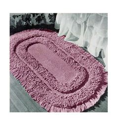 a pink rug is on the floor next to a bed