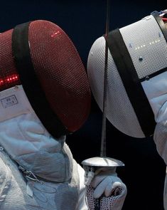 two people in fencing gear with their backs facing each other