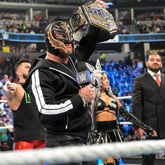 a man in a wrestling ring holding up a trophy