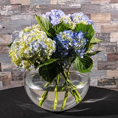 blue and green flowers in a clear vase