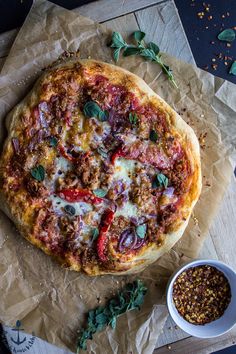 a pizza sitting on top of a wooden cutting board next to a bowl of chili