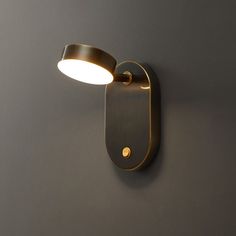 a wall mounted light on the side of a gray wall