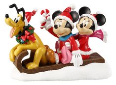 two mickey mouse figurines sitting on top of a sled