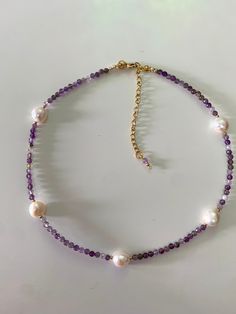 "This charming Necklace is made of Amethyst  and irregular Freshwater Pearl , complemented by gold-plated steel Beaded. Finished with gold-plated steel elements that guarantee the durability of the jewelry.  Its light appearance makes it suitable for any outfit, both jeans and a white t-shirt, and the \"little black dress\". -The necklace has a length of approximately 39 cm + 6,5 cm extension Amethyst beads- 4 mm Freshwater Pearl - 10-11 mm This elegant necklace is a perfect addition to evening dresses or everyday outfits. This necklace is an ideal gift for a loved one or a wonderful way to treat yourself! This necklace emanates good energy because I made it with joy and passion, just like all of my creations!  *This necklace comes with an chain extension, so your can increase or decrease Handmade Purple Pearl Necklace For Gift, Handmade Amethyst Pearl Necklace Gift, Handmade Amethyst Pearl Necklace As A Gift, Purple Amethyst Pearl Necklace With Gemstone Beads, Purple Amethyst Gemstone Beads Pearl Necklace, Purple Amethyst Pearl Necklace, Handmade Purple Pearl Necklace With Round Beads, Pearl Beaded Necklace, The Little Black Dress