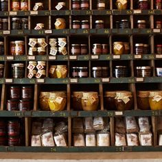 the shelves are filled with different types of jams