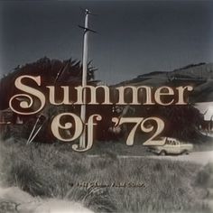 a sign that says summer of'72 in front of an old car on the road