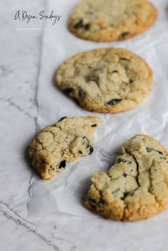 four cookies sitting on top of a piece of wax paper