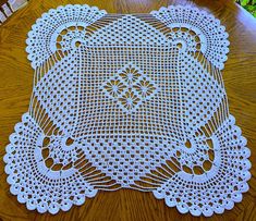 a white doily sitting on top of a wooden table