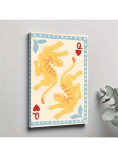 a yellow tiger playing card on a wall next to a plant and potted plant