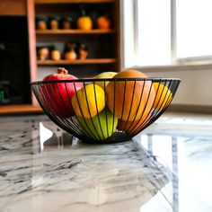 a bowl filled with fruit sitting on top of a marble counter