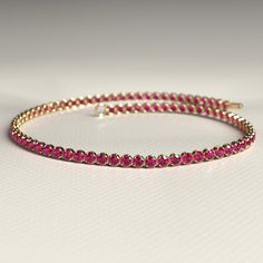 Enhance your style with this stunning Natural Ruby Tennis Bracelet. Handcrafted with care in 14K Gold, this custom stacking bracelet is perfect for July birthdays. Personalize your jewelry collection with this unique piece, or gift it to someone special during Christmas. 𝐅𝐞𝐚𝐭𝐮𝐫𝐞𝐬: * 𝐌𝐚𝐝𝐞 𝐭𝐨 𝐎𝐫𝐝𝐞𝐫 * 𝐌𝐞𝐭𝐚𝐥: 𝟏𝟒𝐊 * 𝐁𝐚𝐧𝐝 𝐂𝐨𝐥𝐨𝐫𝐬: Rose Gold, Yellow Gold & White Gold * 𝐂𝐮𝐬𝐭𝐨𝐦 𝐂𝐫𝐨𝐜𝐨𝐝𝐢𝐥𝐞 𝐋𝐨𝐜𝐤 𝐒𝐭𝐨𝐧𝐞: * 𝐒𝐭𝐨𝐧𝐞 - Natural Ruby * 𝐒𝐡𝐚𝐩𝐞 - Round Cut * 𝐒𝐢𝐳𝐞 - 1.70 MM * 𝐂𝐚𝐫𝐚𝐭 𝐖𝐞𝐢𝐠𝐡𝐭 - 1.82 Carats (Varies with Bracelet Size) * 𝐏𝐢𝐞𝐜𝐞𝐬 - 82 Pieces (Varies with Bracelet Size) * 𝐂𝐨𝐥𝐨𝐫 - Pinkish Red * 𝐂𝐥𝐚𝐫𝐢𝐭𝐲 - VVS-VS ★ 𝐍𝐚𝐭𝐮𝐫𝐚𝐥 𝐌𝐢𝐧𝐞𝐝 & 𝐄𝐭𝐡𝐢𝐜𝐚𝐥𝐥𝐲 𝐒𝐨𝐮𝐫𝐜𝐞𝐝 𝐆𝐞𝐦𝐬𝐭𝐨𝐧𝐞★ 𝐍𝐨𝐭𝐞𝐬: * Stacked Wedding Rings, Birthstone Bracelet, Band Bracelet, Birthstone Bracelets, Engagement Rings Oval, Unique Handmade Jewelry, July Birthstone, Natural Ruby, Special Moments