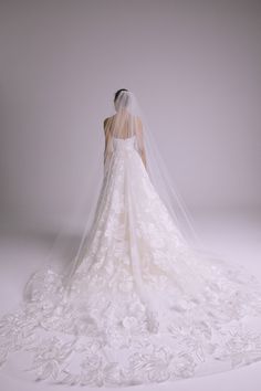 the back of a bride's wedding dress, with veil draped over her shoulder