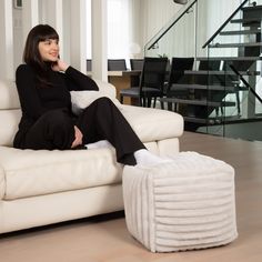 a woman is sitting on a white couch