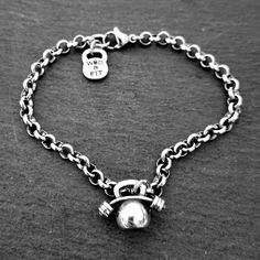 a black and white photo of a chain bracelet with a heart charm on the clasp