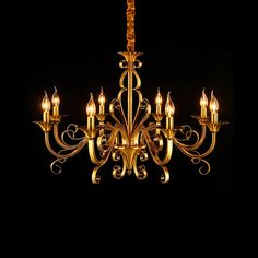 a chandelier with many lit candles in the middle of it, against a black background