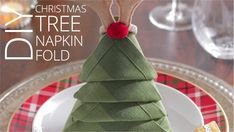 a christmas tree napkin fold on top of a plate