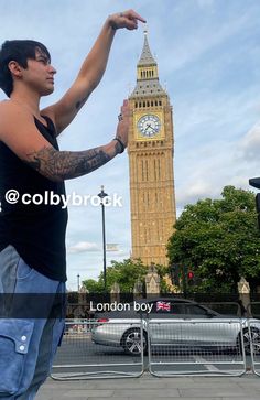 a man pointing at the big ben clock tower