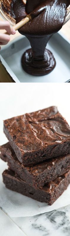 chocolate brownies are stacked on top of each other and one is being dipped in chocolate