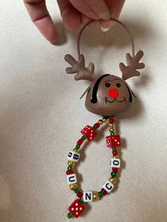 a christmas ornament with a reindeer head and name beads on it's side