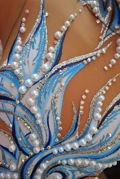 the back of a woman's dress with blue and white beads on it,