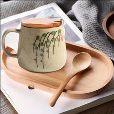 a wooden spoon sitting on top of a plate next to a cup