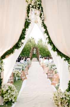 the aisle is decorated with flowers and greenery