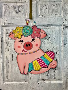 a pig painted on the side of a door with decorations around its neck and legs