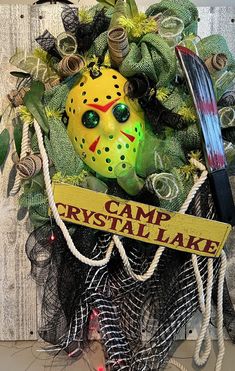 a halloween wreath with a mask and hockey puck on it that says camp crystal lake