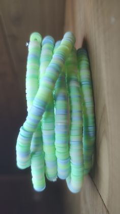 several green and blue beads hanging from a hook