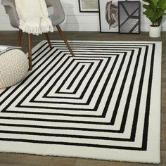 a black and white area rug on the floor with a chair in front of it