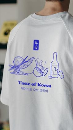 a man wearing a white t - shirt with blue writing that says taste of korea