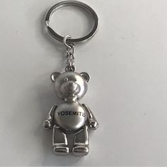 a silver teddy bear keychain with the word yosemite printed on it