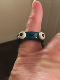 a person's hand with two fake eyes on it and a ring in the shape of an eyeball