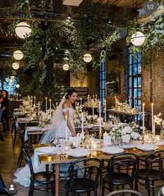 a bride standing in front of a table with candles and flowers