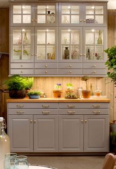 a kitchen filled with lots of counter top space next to a potted plant in a vase