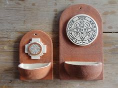 a clay sculpture with a clock on the front and back of it, sitting on a wooden surface